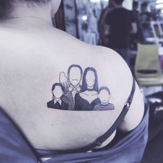 the back of a woman's shoulder with an image of three people on it