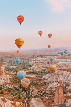 many hot air balloons flying in the sky