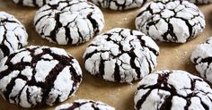 chocolate crinkle cookies with powdered sugar are on a baking sheet, ready to be eaten