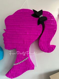 a pink piece of paper that looks like a woman's head is hanging on the wall