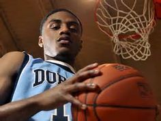 a young man holding a basketball in front of a hoop