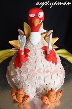 a cake made to look like an angry bird with knife and fork in its beak