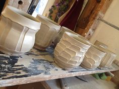 several white vases sitting on top of a table