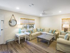 a living room with couches, tables and lamps on the wall next to each other