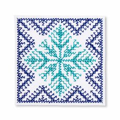 a blue and white cross stitched square with an intricate snowflake design on it