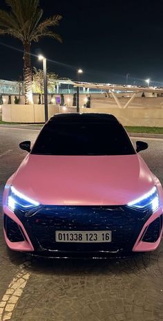 a pink and blue car is parked on the street