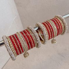 Large stack of luxurious Heavy Pearl & Antique Gold bangles with Deep Red shades finished with jhumka drops and zircon crystals. The perfect stack for any Bride or those wanting to make a statement. Ready to Ship as pictured. Luxury Red Wedding Bangle, Antique Gold Bangles, Pink Bangles, Red Bangles, Wedding Jewelry Sets Bridal Jewellery, Bridal Chura, Fashion Words, Red Shades, Bridal Choker