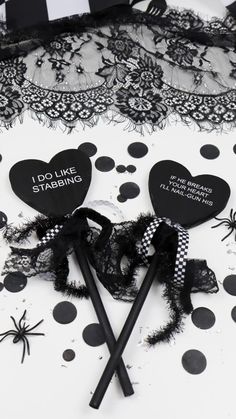 two black heart shaped paper napkins sitting on top of a table