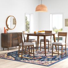 a dining room table and chairs with an area rug