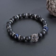 "--- Description --- The bracelet is made with stretch material - professional high quality strong stretch cord , to adjust your wrist size . Material: black panther charm Length: 7.5 inch Width: 8mm Bead size: 8mm --- Tips --- If you want to order two bracelets, please select \"TWO pcs\" and please note when placing the order. (Example: P1+P3) Thank you. --- Packaging --- Each Item is well packed in cloth bag, ready to give away as gift. As this item is handmade, please allow for small variatio Black Panther Bracelet, Superhero Bracelets, Forever Bracelet, Charm Beaded Bracelet, Black Panthers, Jewelry Mens, Cloth Bag, Mens Beaded Bracelets, Gold Crown