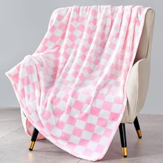 a pink and white checkered blanket sitting on top of a chair