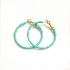 "A pair of mint green hoops, wrapped by hand in the UK. These earrings are cheery, bright and perfect for your summer vacation!  The hoop itself has been wrapped with quality embroidery thread in a shade of mint green, giving them a huge pop of colour.  A nice change from the usual gold and silver hoops.  Measuring approximately 1.25\" (3cm)   in diameter, these hoops are relatively small. They are also very lightweight and are comfortable to wear all day long.  The ear post has a lever mechanis Handmade Adjustable Green Wrap Earrings, Adjustable Handmade Green Wrap Earrings, Green Hoop Earrings For Gifts, Green Hoop Earrings As Summer Gift, Green Hoop Earrings, Summer Gift, Handmade Small Green Hoop Earrings, Green Hoop Earrings For Summer, Green Small Hoop Earrings For Summer, Small Green Hoop Earrings For Summer