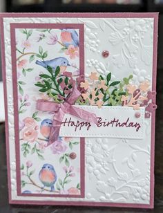 a close up of a birthday card with flowers and birds on the front, in pink