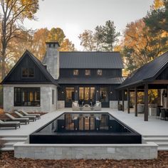 a house with a pool in front of it and lounge chairs around the pool area