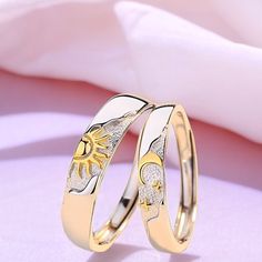 two gold wedding rings with flowers on them