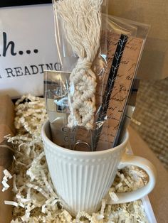 a coffee cup filled with some kind of rope and paper on top of a table