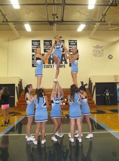 the cheerleaders are doing tricks on the basketball court