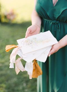 a woman in a green dress holding some cards