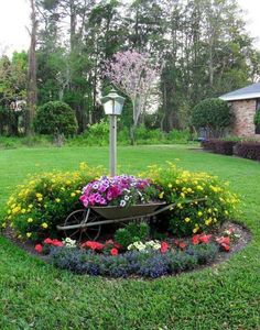 a wheelbarrow with flowers in the middle of it and a lamp post behind it