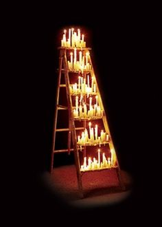 a ladder filled with lit candles in the dark