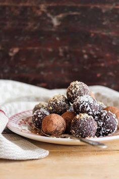 a plate full of chocolate truffles sitting on a table next to a napkin