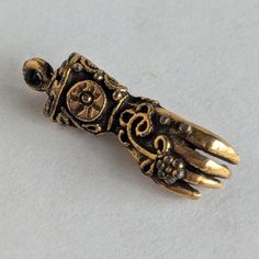 This gorgeous glove charm is highly ornate with exquisite details -- maybe baroque in style? The charm is perfect for a bracelet or necklace and brings to mind Victorian gloved ladies seeking out suitors at a ball. I'm not certain how many carats the gold is, but from researching, I believe it to be 14 or 18ct. It is possible that these are metal gold plated/coated. Measures approximately 7/8" in length I have NOT attempted to clean it as I do not want to damage the integrity of the piece. Free