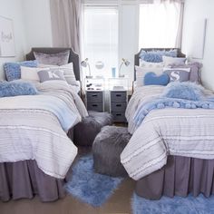 two beds with blue and white comforters in a bedroom next to a small window