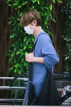 a man wearing a face mask and carrying a black bag