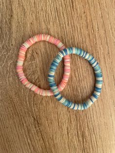 two bracelets sitting on top of a wooden table