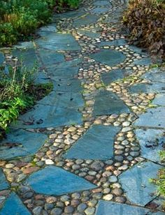 a stone path in the middle of a garden