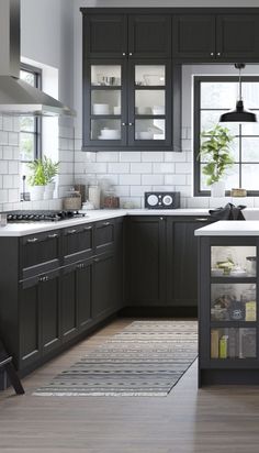 a kitchen with black cabinets and white counter tops