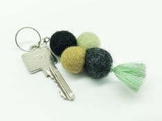 a keychain with several balls and tassels attached to it on a white surface