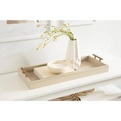 a white tray with a vase and bowl on it sitting on top of a table