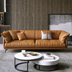 a brown leather couch sitting next to a white coffee table