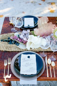 a table set with place settings and flowers