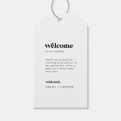 a white welcome tag with the words, welcome to our wedding written in black on it