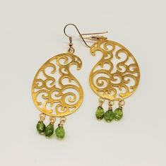 "Carved 18K gold plated paisley earrings with clear natural peridot beads. The paisley pattern is delicately carved in an open lattice style, embellished with bright clear gemstones. The earrings are  a contemporary take  on an ancient motif, the paisley. They are bold and feminine. The perfect accessory to enhance your look on a night out. The paisley motif has travelled from East to West capturing the imagination of many artisans, architects, and fashion designers. It first sprang up in Ancien Elegant Green Earrings With Gold Beads, Gold Teardrop Peridot Earrings, Peridot Dangle Earrings In Gold, Clear Gemstones, Paisley Earrings, Paisley Motif, Carnelian Beads, Paisley Pattern, Look On