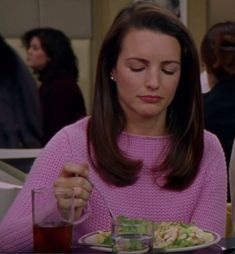 a woman sitting at a table eating food