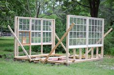 two wooden structures sitting on top of a lush green field