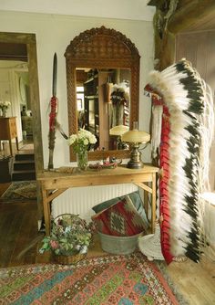 a room with a table, mirror and decorative items on the floor in front of it