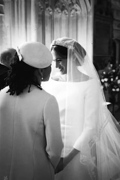 two women standing next to each other in front of a church alter with one woman wearing a veil