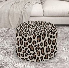 a leopard print ottoman sitting on top of a rug