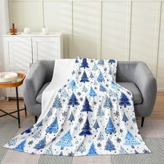 a blue and white christmas tree print blanket on a chair in a living room with two chairs