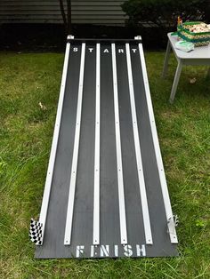 a table that is in the grass with some food on it and an air hockey board next to it