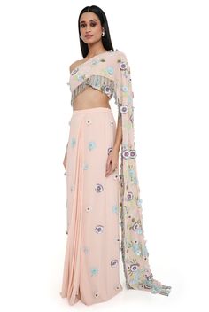 Blush pink georgette embroidered choli with attached pallu with hanging colorful tassels and embroidered pre-stitched skirt. Disclaimer: Since we are a made-to-measure brand and our dyeing process and embroidery are handcrafted, there may be slight variations in the color and embroidery of the actual product. The print placement may also vary from what is represented in the images shown on the product page. Pink Embellished Pre-draped Saree For Navratri, Embellished Pink Pre-draped Saree For Navratri, Designer Floor-length Sets With Tassels, Festive Pink Sharara With Tassels, Designer Tassel Dresses For Navratri, Festive Pink Tassel Sharara, Pink Embellished Pre-draped Saree For Festivals, Embellished Pink Pre-draped Saree For Festivals, Designer Pre-draped Saree With Tassels