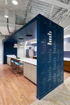 an office with blue walls and wooden flooring is pictured in this image, there are several chairs around the table