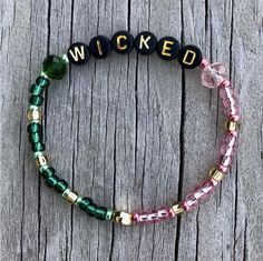 a close up of a bracelet on a wooden surface with words written in small letters