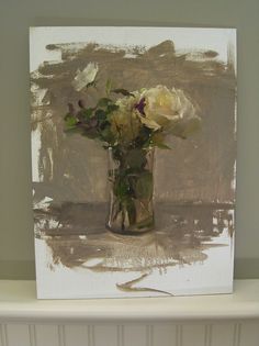 a vase filled with white flowers on top of a shelf next to a wall mounted painting