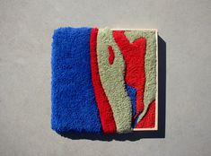 a towel is laying on top of a blue and red rug that looks like an abstract painting