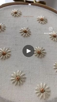 the video is showing how to sew flowers on fabric with needle and button holes